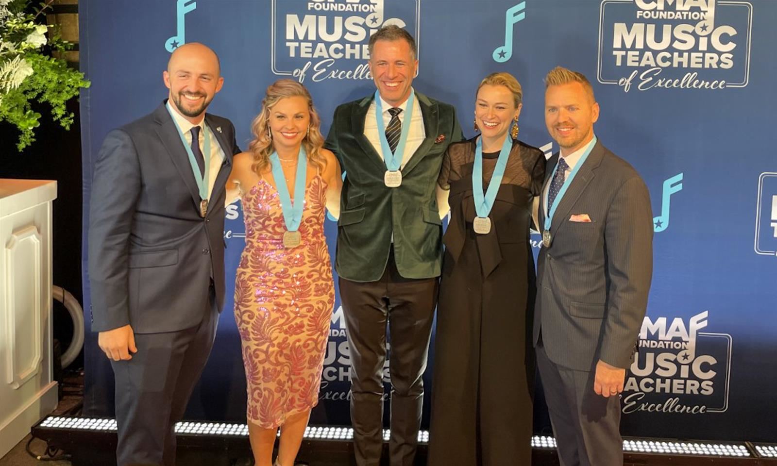 Five teachers smile at an awards ceremony